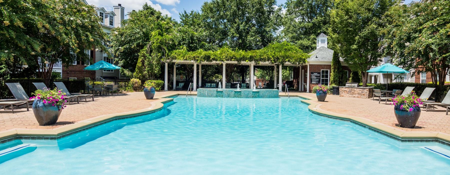 a swimming pool with trees and a building in the background